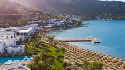 Ege Denizi’nin berrak suları, zeytin ağaçlarının gölgesi altında huzurlu bir