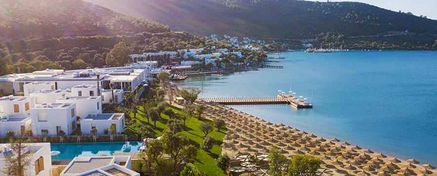 Ege Denizi’nin berrak suları, zeytin ağaçlarının gölgesi altında huzurlu bir