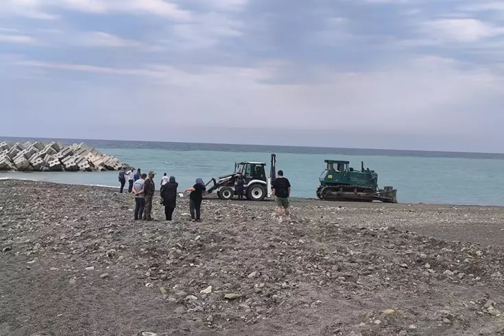 Bir kadın, Kastamonu'nun Abana ilçesinde plajda dinlenirken temizlik yapan bir